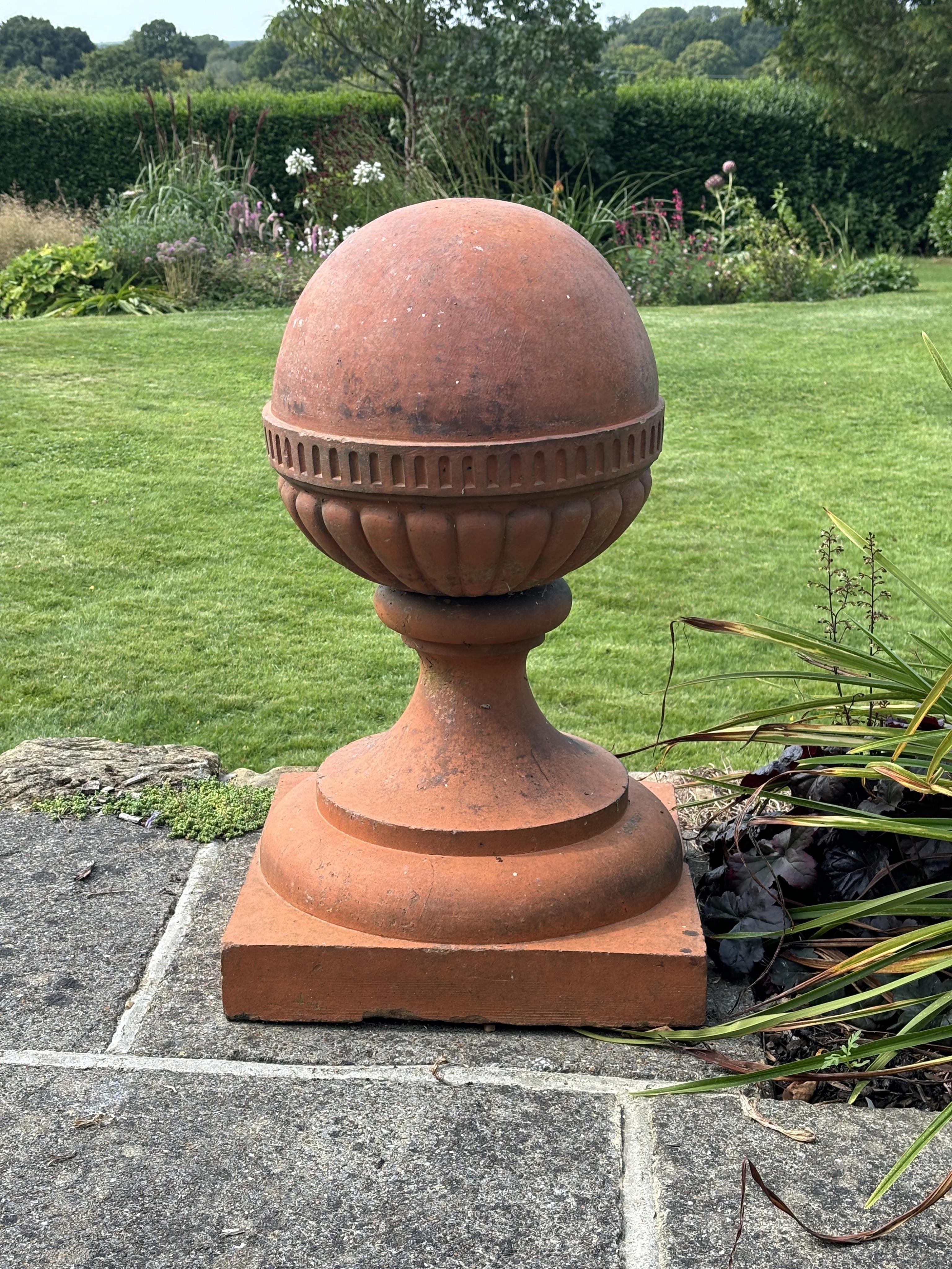 A large pair of Victorian terracotta ball finials, height 64cm, diameter 46cm. Condition -weathered, some chipping to the bases